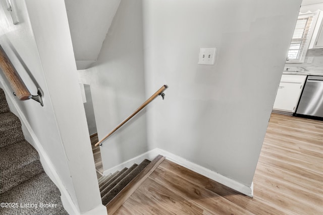 staircase with wood finished floors and baseboards