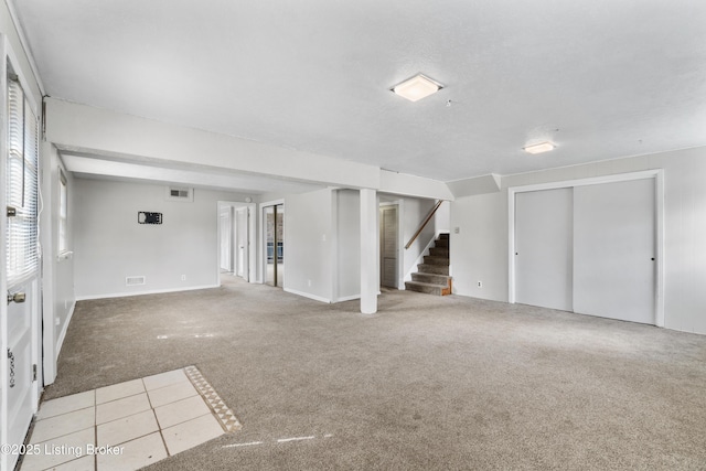 interior space featuring light carpet, stairway, and visible vents