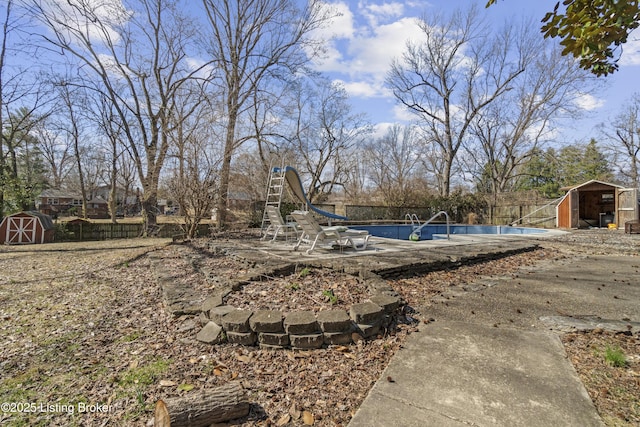 view of yard with an outbuilding, an outdoor pool, and a shed