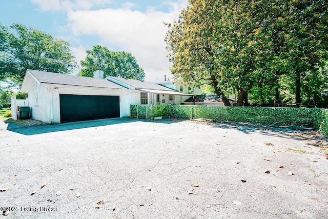 ranch-style house with an attached garage, driveway, fence, and brick siding