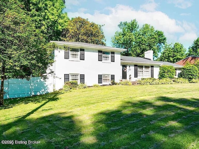 split level home with a chimney and a front yard