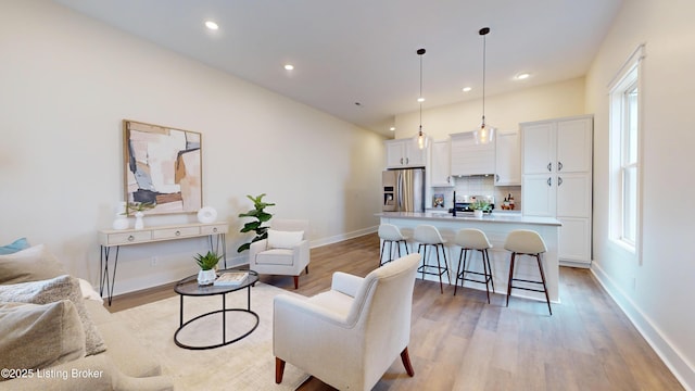 living room with light wood finished floors, baseboards, and recessed lighting