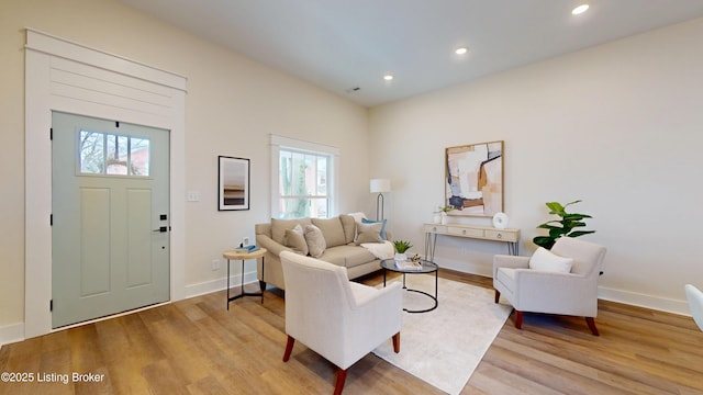 living area featuring baseboards, wood finished floors, and recessed lighting