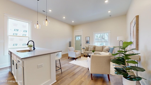 living room featuring baseboards, light wood-type flooring, and recessed lighting