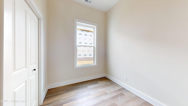 unfurnished bedroom featuring a closet, visible vents, light wood-style flooring, and baseboards