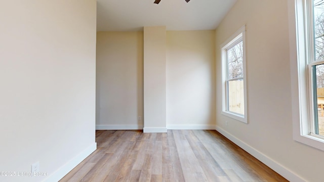 unfurnished room with ceiling fan, light wood-type flooring, and baseboards