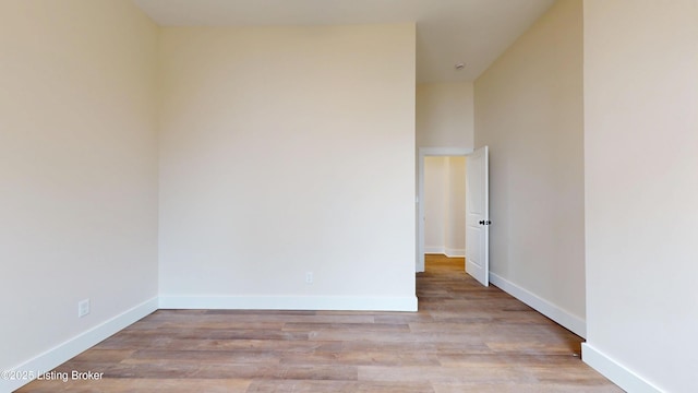 spare room with wood finished floors and baseboards