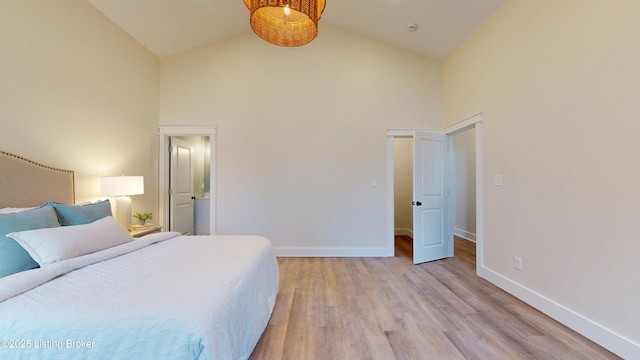 bedroom with high vaulted ceiling, light wood-style flooring, and baseboards