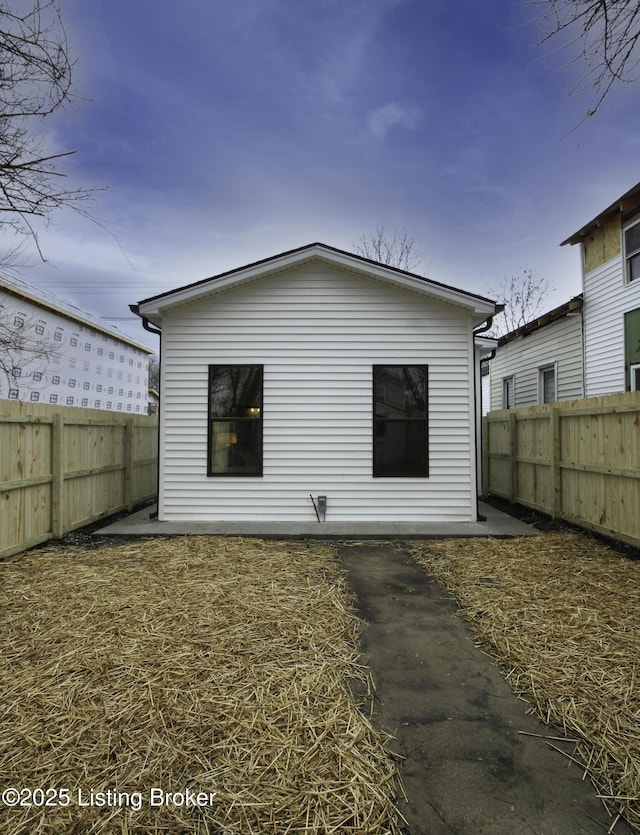 rear view of house featuring a fenced backyard