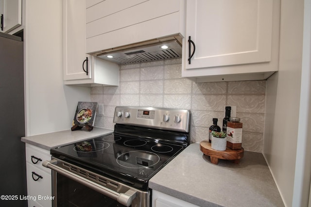 kitchen with refrigerator, electric range, decorative backsplash, white cabinetry, and extractor fan