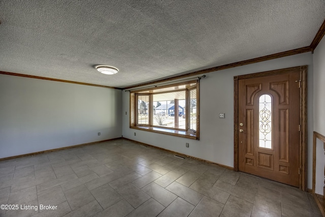 entryway with ornamental molding, a textured ceiling, and baseboards