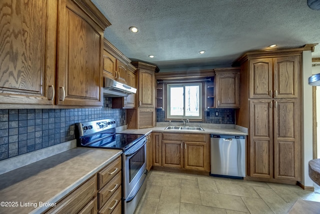 kitchen featuring brown cabinets, open shelves, appliances with stainless steel finishes, a sink, and under cabinet range hood