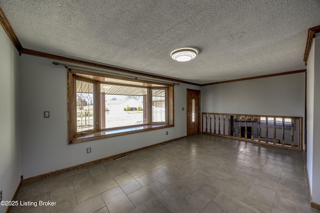 empty room featuring a textured ceiling, ornamental molding, and baseboards