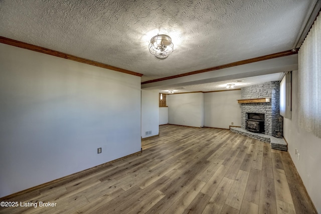 unfurnished living room with a textured ceiling, a fireplace, wood finished floors, and crown molding