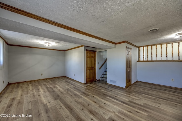 finished basement with stairs, ornamental molding, wood finished floors, and visible vents