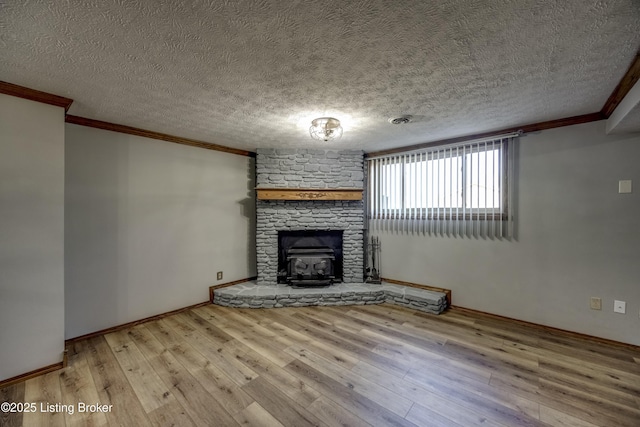 unfurnished living room with ornamental molding, hardwood / wood-style floors, a textured ceiling, and visible vents