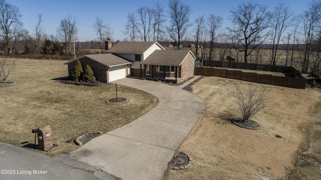 view of front of house featuring driveway, a chimney, an attached garage, and fence