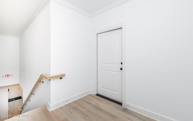 interior space featuring baseboards, wood finished floors, and crown molding