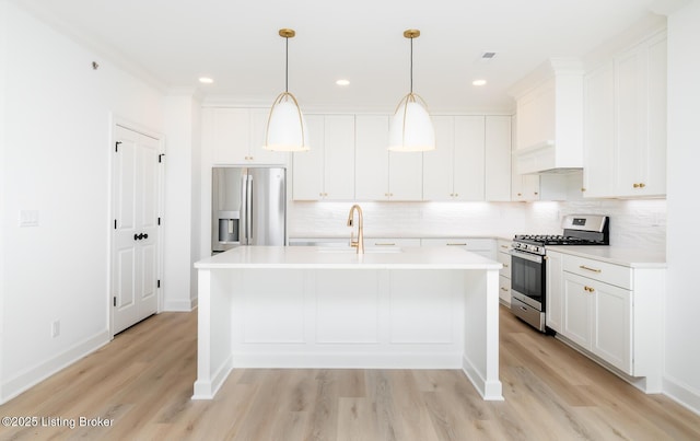 kitchen featuring a sink, white cabinets, light countertops, appliances with stainless steel finishes, and an island with sink