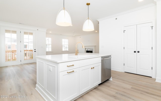 kitchen with crown molding, a sink, a high end fireplace, dishwasher, and pendant lighting