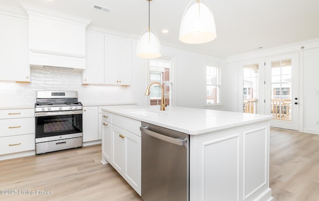 kitchen featuring visible vents, ornamental molding, light countertops, stainless steel appliances, and a sink