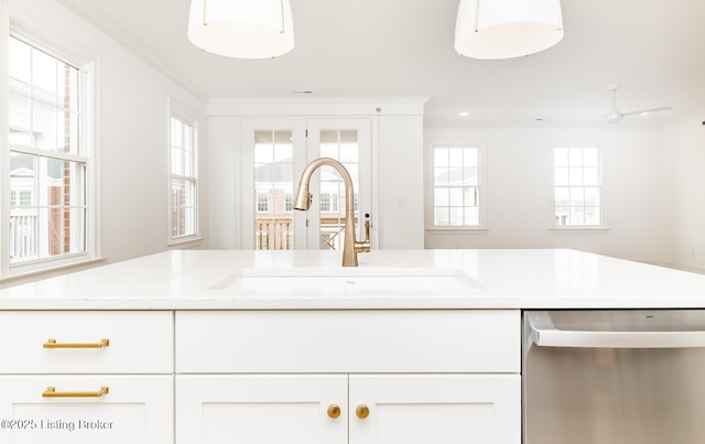 kitchen featuring ornamental molding, light countertops, dishwasher, and a sink