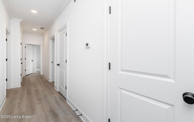 hallway featuring baseboards, light wood-style flooring, visible vents, and recessed lighting