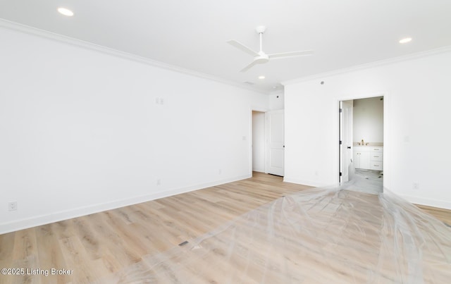 spare room with baseboards, ornamental molding, and light wood-style flooring