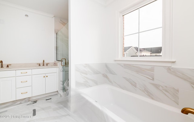 bathroom with ornamental molding, a stall shower, a garden tub, and a sink