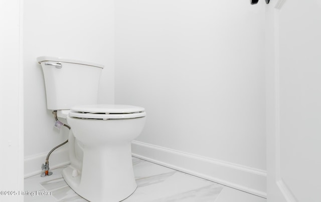 bathroom with marble finish floor, baseboards, and toilet