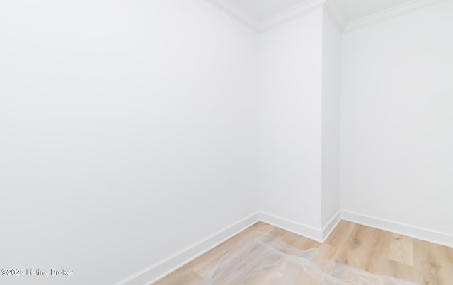 unfurnished room with baseboards, light wood-type flooring, and crown molding