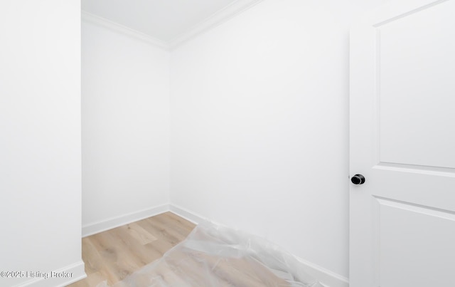 interior space with baseboards, light wood-type flooring, and crown molding