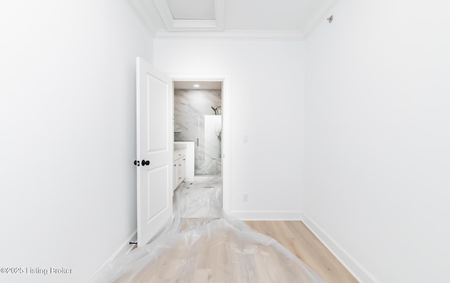 hall with ornamental molding and baseboards