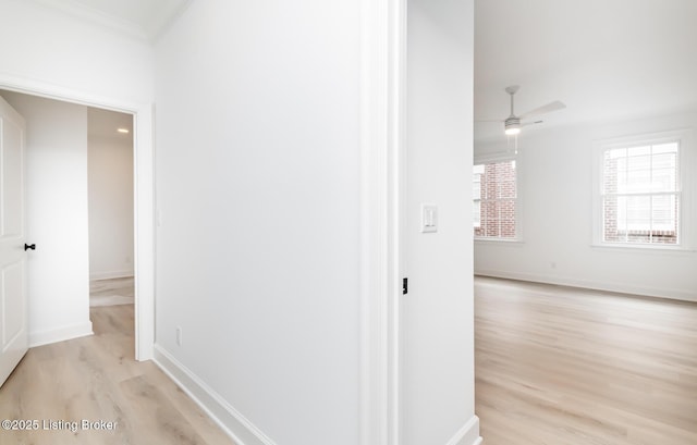 hall with light wood-type flooring and baseboards