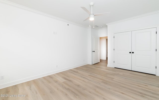 unfurnished bedroom with baseboards, a closet, light wood-type flooring, and crown molding