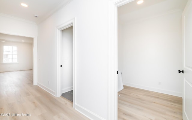 hallway featuring baseboards, crown molding, light wood-style flooring, and recessed lighting