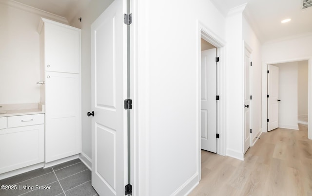 corridor featuring recessed lighting, wood finished floors, visible vents, baseboards, and crown molding