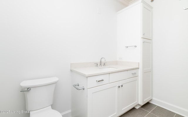 bathroom with tile patterned flooring, baseboards, vanity, and toilet