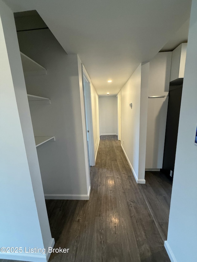 hallway with dark wood-style floors and baseboards