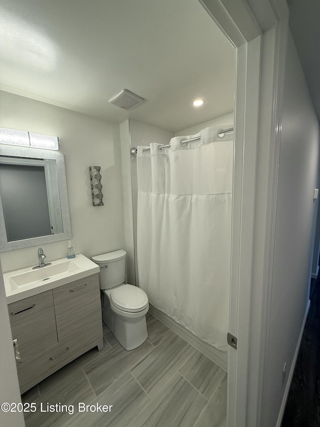 bathroom featuring toilet, curtained shower, visible vents, and vanity