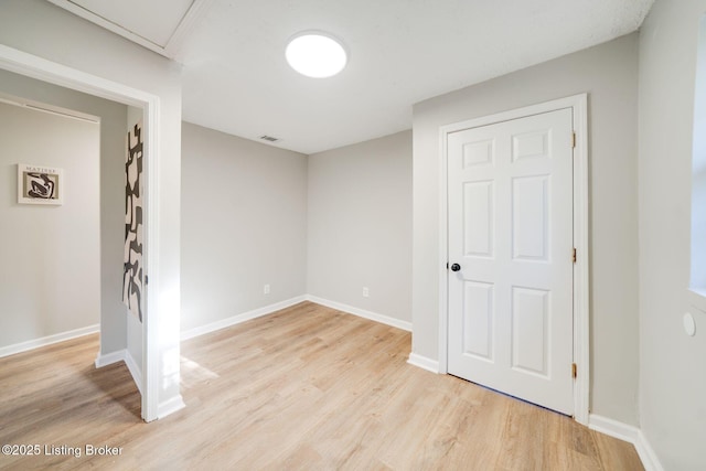 empty room featuring baseboards, visible vents, and light wood-style flooring