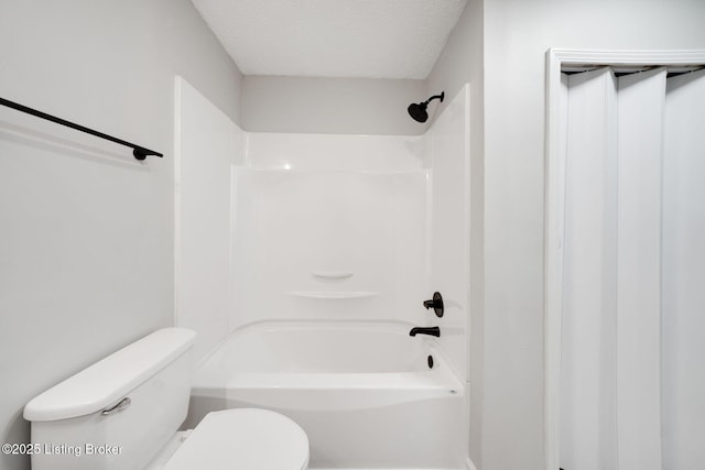 full bath featuring a textured ceiling, toilet, and bathtub / shower combination
