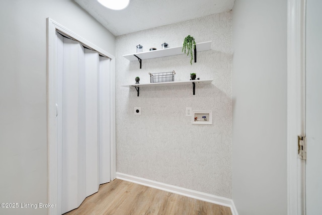 clothes washing area featuring light wood-type flooring, baseboards, washer hookup, electric dryer hookup, and laundry area