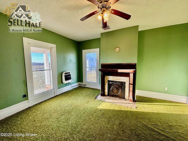 unfurnished living room with visible vents, a fireplace with flush hearth, heating unit, a textured ceiling, and carpet floors