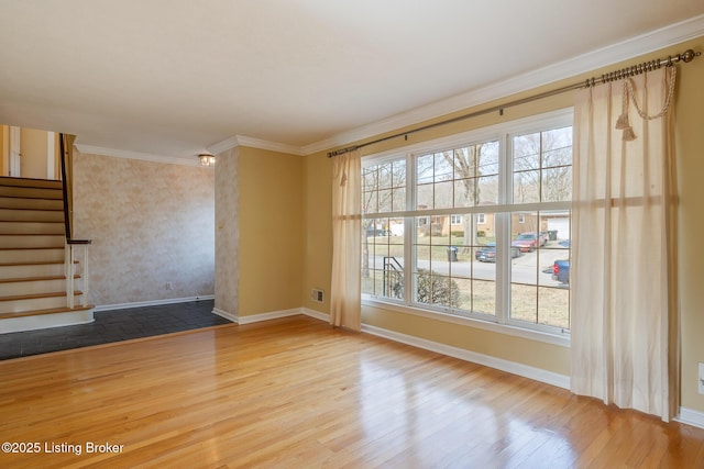 spare room featuring crown molding, stairs, baseboards, and wood finished floors