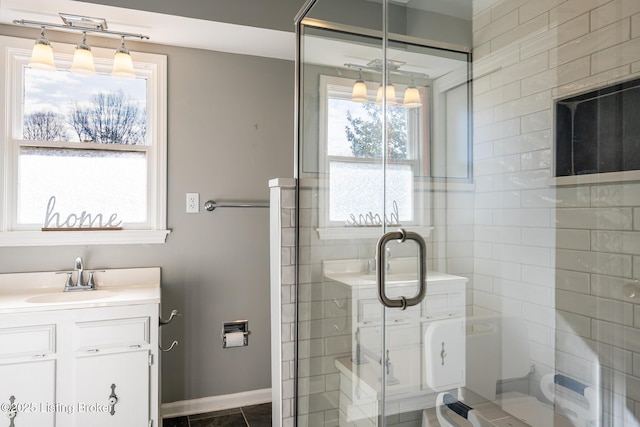 full bathroom with baseboards, a shower stall, and vanity