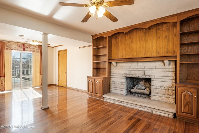 unfurnished living room with light wood-style floors, a fireplace, baseboards, and a ceiling fan