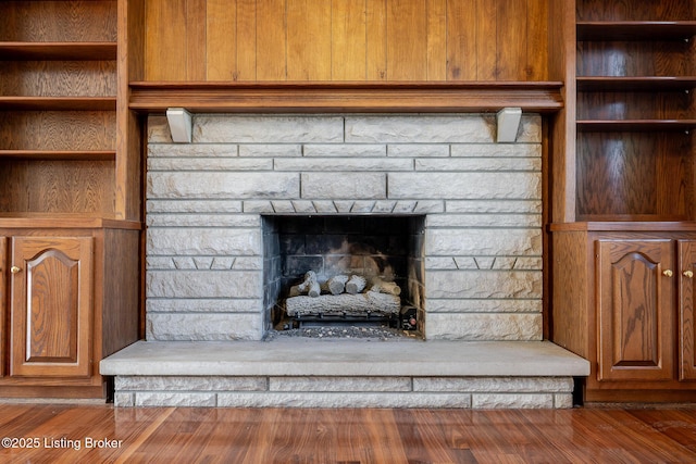 room details featuring a stone fireplace and wood finished floors