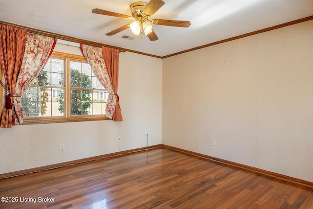 spare room with baseboards, visible vents, wood finished floors, and ornamental molding