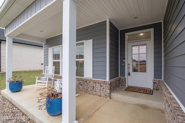 property entrance featuring stone siding and covered porch